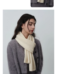 Détail de la texture en maille côtelée blanc crème et de la matière douce de l'écharpe d'hiver