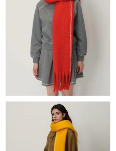 Close-up of red and yellow cashmere-feel scarves with white whipstitch edges and long fringes