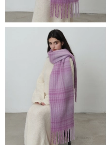 Detail of soft purple and pink checkered scarf with long fringe on a white dress