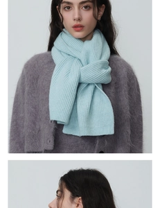 Détail de l'écharpe en laine tricotée bleu clair montrant la texture épaisse et le style