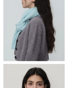 Détail d'une écharpe en grosse maille bleu clair et d'un cardigan doux en mohair gris