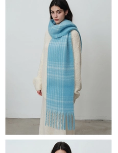 Detail shot of light blue checkered scarf showing long fringe and soft knit texture