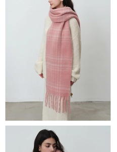 Detail of pink plaid boucle scarf with long tassels showing warm plush texture and patterns
