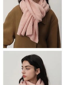 Détails de maille d'une écharpe en laine rose pâle assortie à un manteau en laine marron
