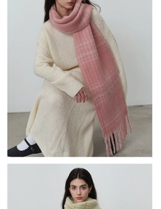 Detail of pink plaid knit scarf with long tassels paired with soft beige knit dress