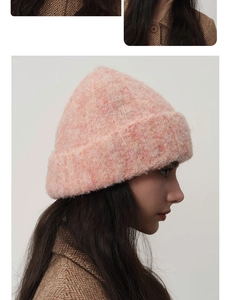 Close-up of pink fluffy wool knit hat showing textured mohair blend and folded cuff details