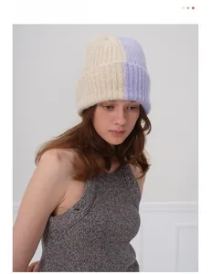 Gros plan du bonnet en laine tricoté bicolore porté par un mannequin en studio