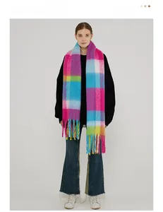 Close-up of thick winter scarf with vibrant colorful plaid pattern and long tassel details
