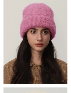 Close-up detail of fluffy bright pink wool beanie with thick knit texture and wide folded brim
