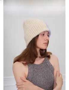 Détail du bonnet en maille épaisse avec design bicolore en beige et lavande