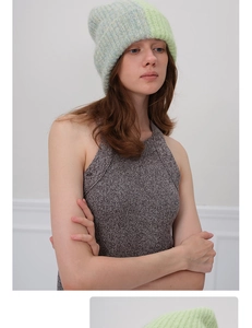 Détail du bonnet en maille épaisse menthe et gris avec un gilet en tricot à col licou