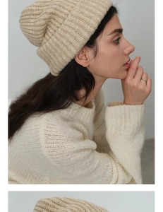 Detail of oatmeal chunky knit beanie and cream white sweater on model for winter warmth
