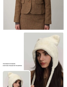 Close-up of cute cream furry cat ear beanie hat paired with a herringbone wool blazer