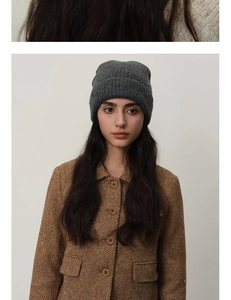 Detailed texture of dark grey ribbed knit beanie made from warm wool blend fabric