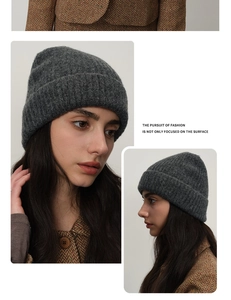 Detailed close-up of dark grey ribbed knit beanie with stylish folded cuff design