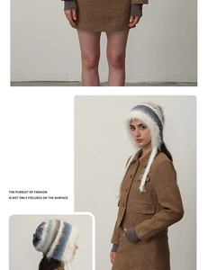 Detail of white, blue, and grey striped plush earflap hat with long braided tassels