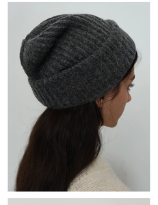 Close-up of thick ribbed knit texture and cuffed brim on a dark grey wool blend beanie