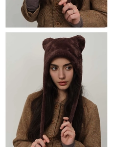 Close-up of fluffy dark brown faux fur trapper hat with cute animal ears for winter