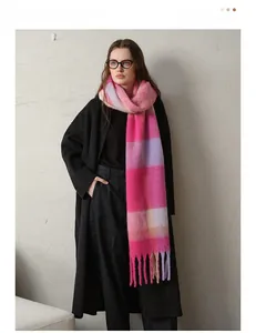 Detail shot of chunky plaid scarf featuring vibrant pink and purple wool tassels