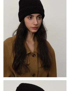 Detailed texture of black ribbed knit wool beanie paired with a classic camel wool coat