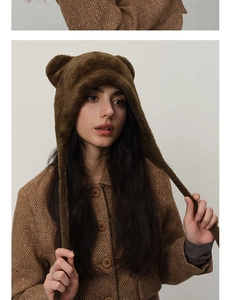 Detail shot of brown plush animal ear hood with vintage herringbone coat texture