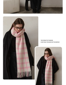 Detail of soft pink and white plaid wool scarf featuring long fringed edges for winter