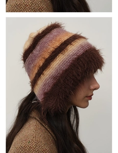 Detailed side view of a fluffy gradient knit hat with plush trim and warm earflaps