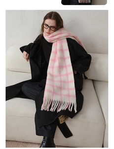 Detailed view of soft pink and white checkered wool scarf with long tassel hem details