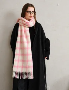 Close-up of thick pink and white plaid wool scarf with decorative long tassels