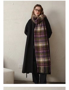 Detail of checkered mohair scarf with fringes worn over a long black winter coat