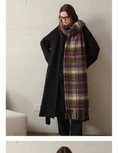 Detailed view of thick checkered mohair scarf with tassels over a black winter wool coat