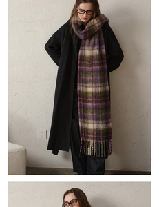 Detail of purple and green plaid mohair scarf texture with long fringe on a winter coat