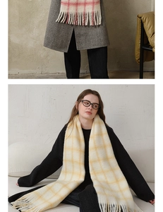 Detailed macro view of soft pink and yellow plaid wool scarf with long tassel textures