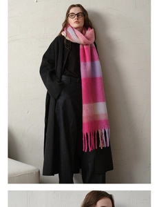 Detail shot of pink and purple plaid scarf with thick tassels and soft wool-like texture