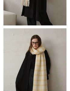 Detail of soft pink checkered wool scarf with long tassels paired with black coat
