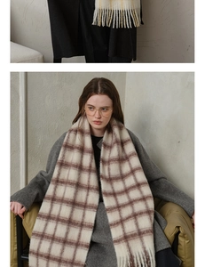 Close-up of thick wool plaid scarf with soft fringe edges and warm beige texture