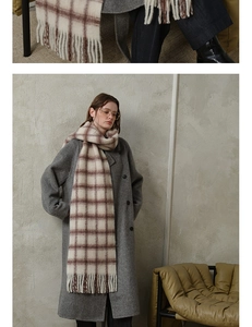 Detail of soft beige and brown plaid wool scarf texture with long fringe tassels