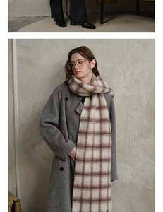 Detail of soft pink and beige wool plaid scarf paired with a grey coat for winter