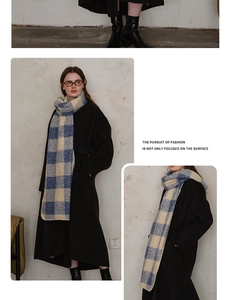 Close-up of blue and beige plaid woolen scarf with thick knit texture and fringe detail