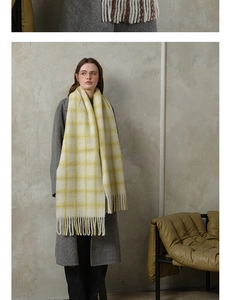 Detail of soft yellow and cream plaid wool scarf with long decorative fringes
