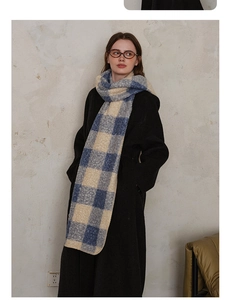 Close-up of blue and beige checkered wool scarf with thick fringe and soft texture
