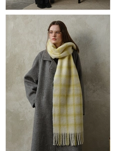 Close-up detail of soft beige plaid wool scarf with elegant tassels and warm texture
