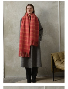 Long wool plaid scarf with red and yellow tassels worn with a classic winter coat