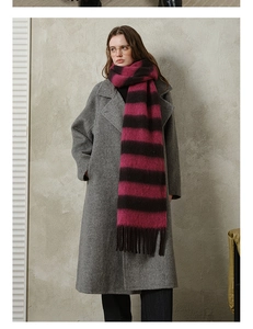 Close-up of thick plaid scarf with magenta and brown stripes and soft fringe detail