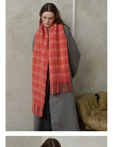 Close-up of soft pink and yellow plaid wool scarf with long decorative fringe detail