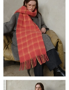 Close-up of orange and beige checkered wool scarf featuring soft tassels and thick texture