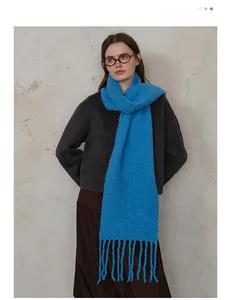 Detailed close-up of blue wool knit scarf showing fringe details and bouclé texture