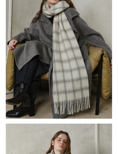 Detailed view of gray and white plaid wool scarf with soft tassels for autumn/winter