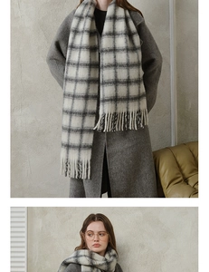 Detail view of thick black and white plaid wool scarf with classic long fringed edges