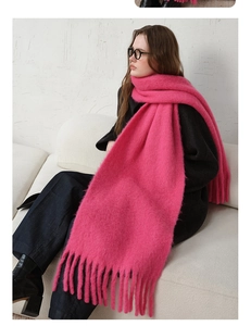 Close-up of vibrant pink wool blend scarf with thick fringe on a dark coat